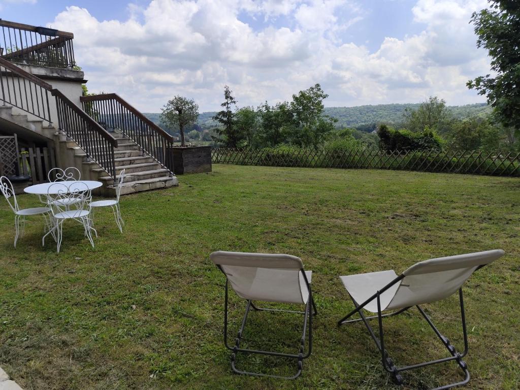 - une table et des chaises dans la cour d'une maison dans l'établissement Logement en pleine nature à la campagne, à Saint-Cyr-sur-Morin