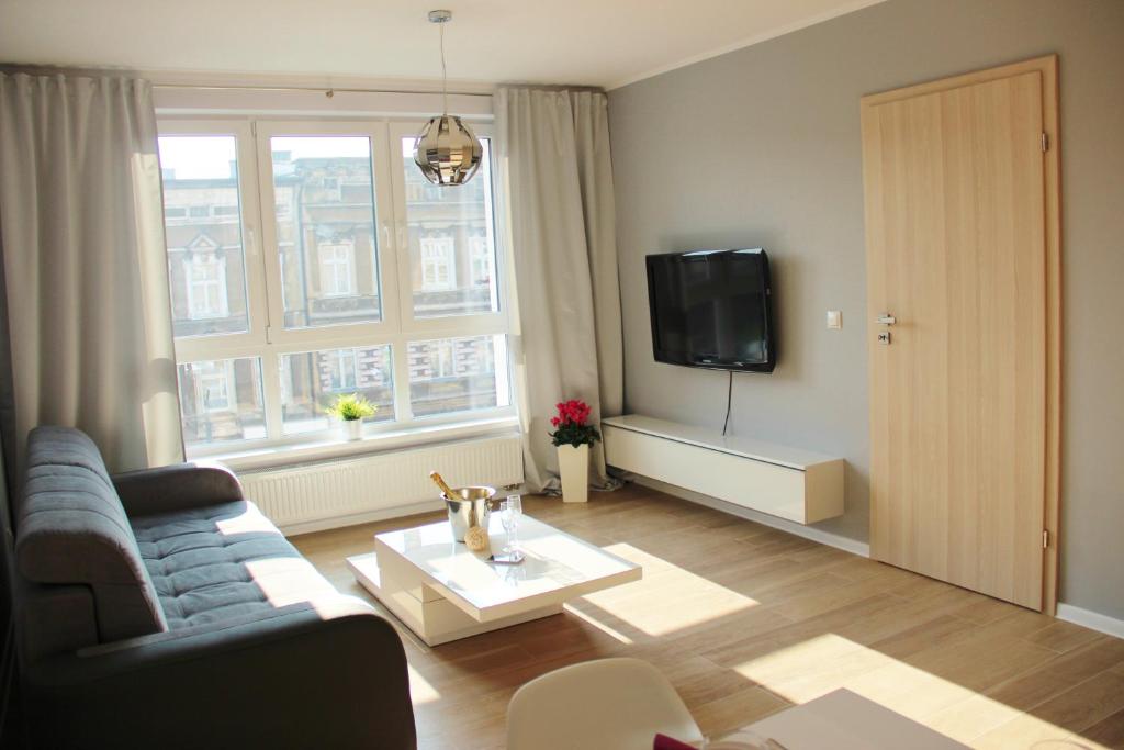 ein Wohnzimmer mit einem Sofa und einem TV in der Unterkunft SMM Apartament Stettin in Stettin