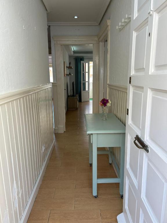 ein Flur mit einem Tisch, auf dem eine Vase mit Blumen steht in der Unterkunft Apartamento Aguadulce Playa in Aguadulce