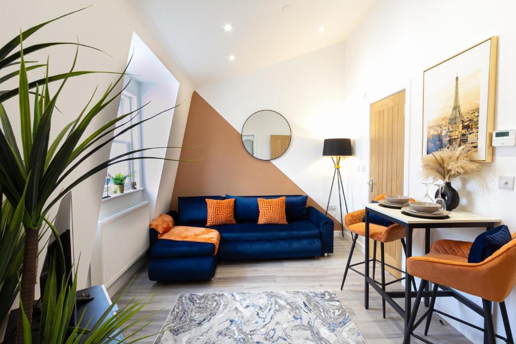 a living room with a blue couch and a table at The Lanes Diamond - Rose Platinum Properties in Brighton & Hove