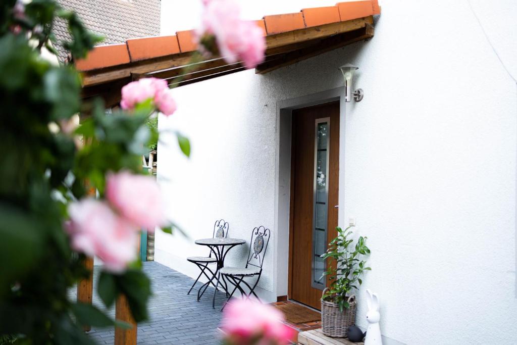 a patio with two chairs and a table in front of a building at Anca's Haus in Schwanstetten