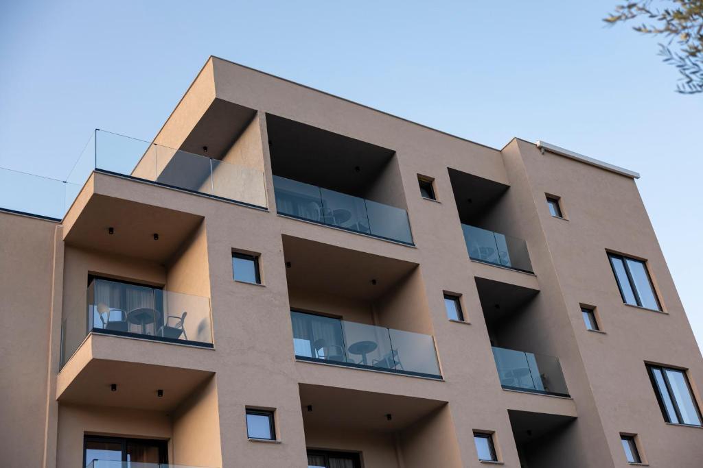 an apartment building with chairs in the balconies at Diol Hotel Ksamil in Ksamil