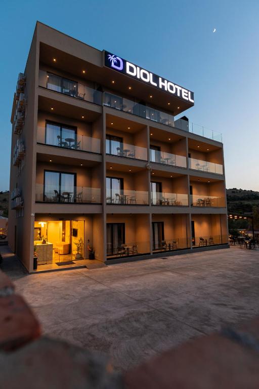 a large hotel with a sign on the front of it at Diol Hotel Ksamil in Ksamil