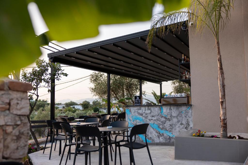 a restaurant with tables and chairs under awning at Diol Hotel Ksamil in Ksamil