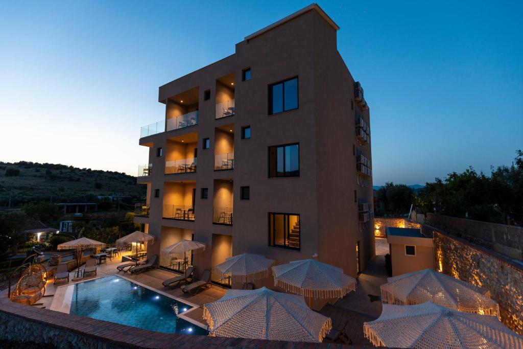 a hotel with a pool and umbrellas in front of it at Diol Hotel Ksamil in Ksamil