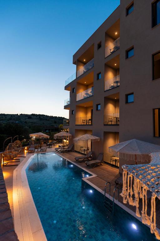 a hotel with a swimming pool in front of a building at Diol Hotel Ksamil in Ksamil
