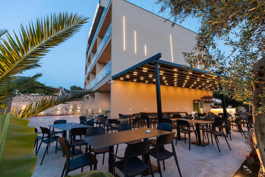 a restaurant with tables and chairs in front of a building at Diol Hotel Ksamil in Ksamil