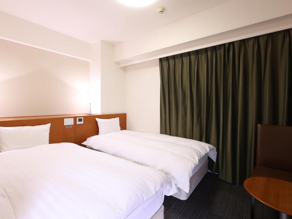 Postel nebo postele na pokoji v ubytování Dormy Inn Takasaki