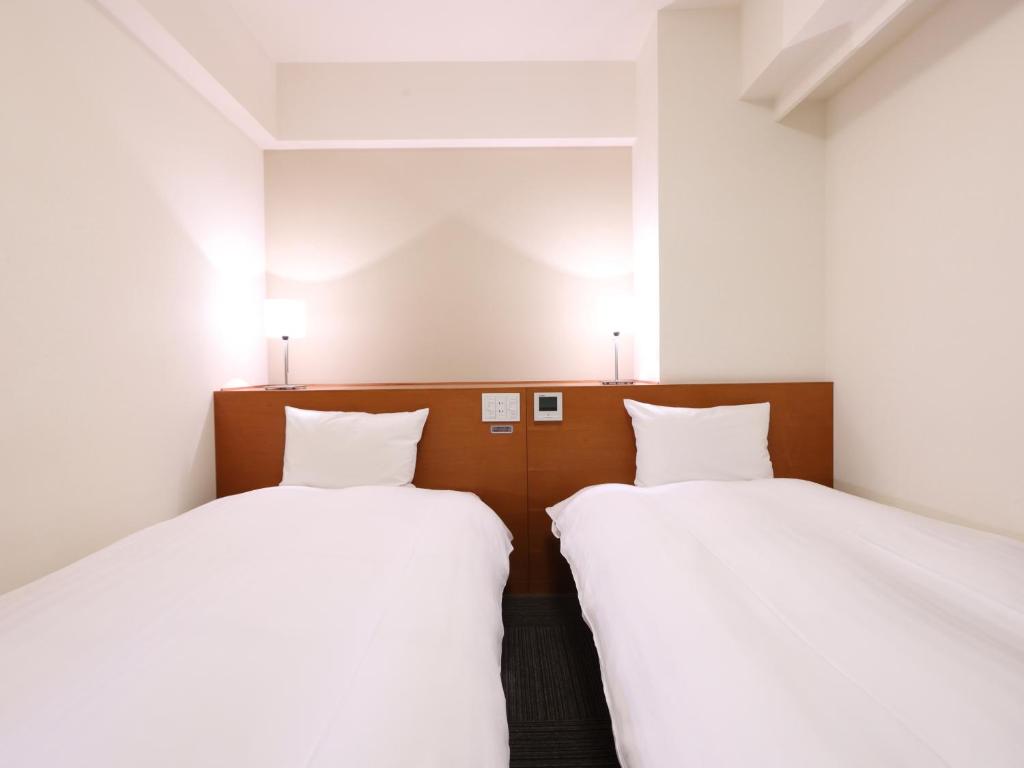 Postel nebo postele na pokoji v ubytování Dormy Inn Takasaki