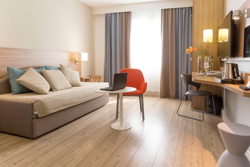 a living room with a couch and a laptop on a table at Best Western Plus Ajaccio Amirauté in Ajaccio
