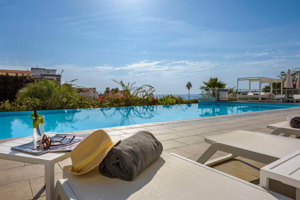a view of a swimming pool with a table and chairs at Best Western Plus Ajaccio Amirauté in Ajaccio