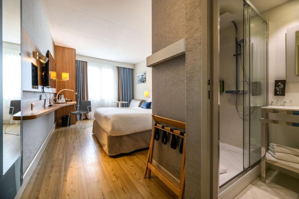 a hotel room with a bed and a shower at Best Western Plus Ajaccio Amirauté in Ajaccio