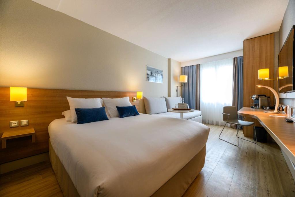 a hotel room with a large bed and a desk at Best Western Plus Ajaccio Amirauté in Ajaccio