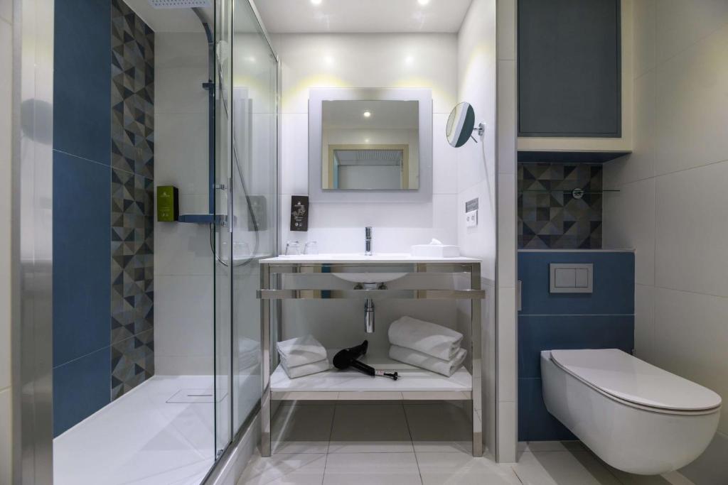 a bathroom with a sink and a toilet at Best Western Plus Ajaccio Amirauté in Ajaccio