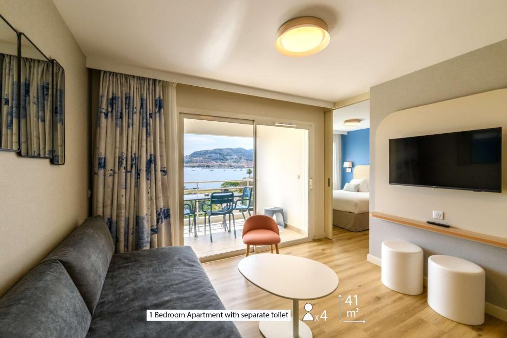 a living room with a couch and a view of the ocean at Best Western Plus Ajaccio Amirauté in Ajaccio