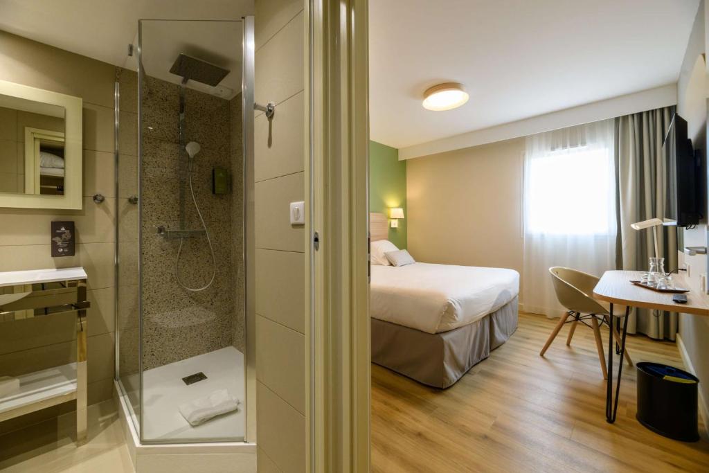 a hotel room with a bed and a shower at Best Western Plus Ajaccio Amirauté in Ajaccio
