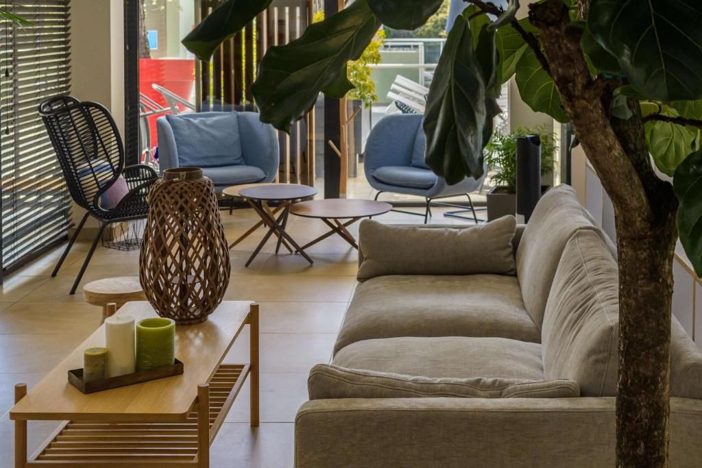 a living room with a couch and a table at Best Western Plus Ajaccio Amirauté in Ajaccio