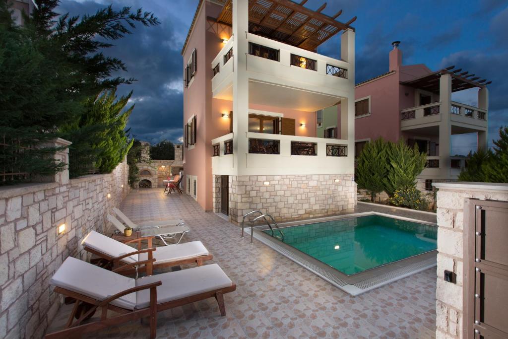 una casa con piscina al lado de un edificio en Villa Sia, en Adelianos Kampos