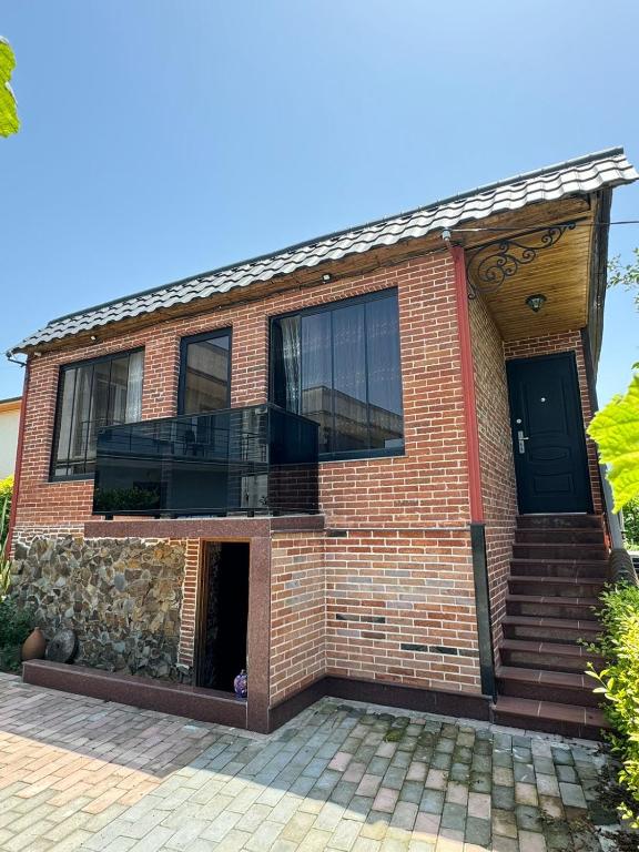 a brick house with a black door at Orion Villa 1 in Batumi
