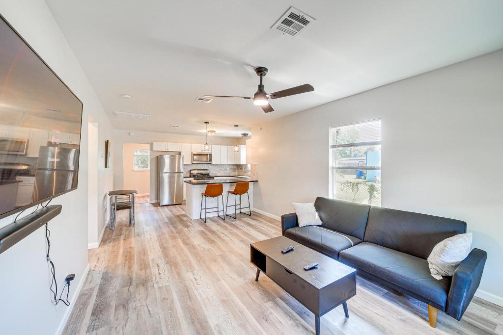 a living room with a couch and a kitchen at Remodeled Tulsa House with Yard about 4 Mi to Downtown! in Tulsa
