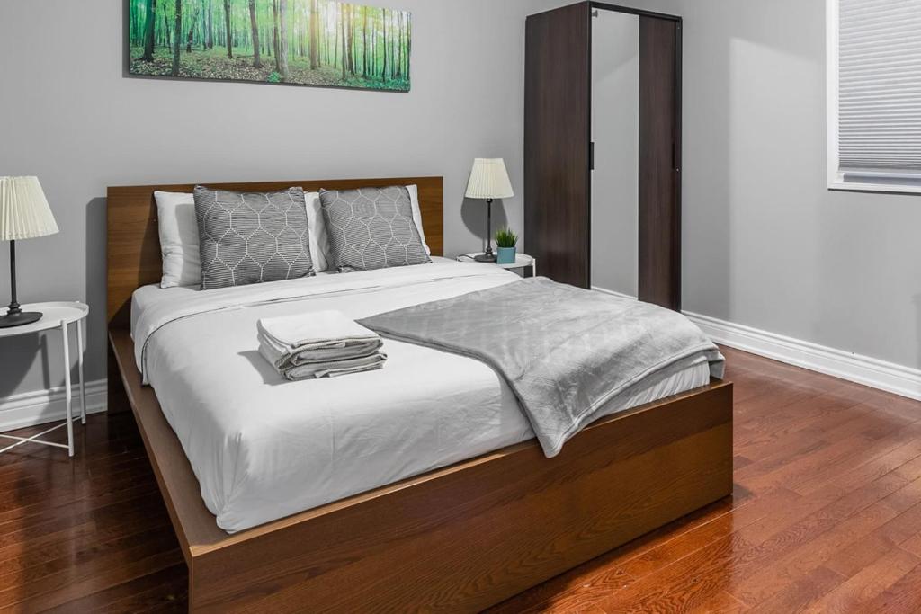 a bedroom with a large bed with white sheets and pillows at Pet-Friendly Apartment on Ossington Ave in Toronto