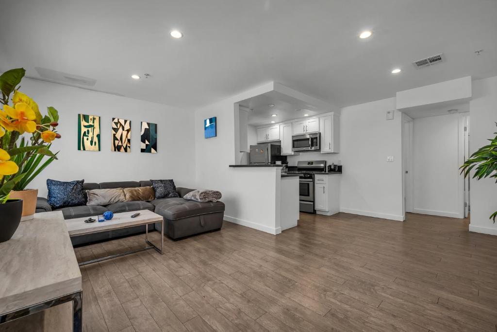 a living room with a couch and a kitchen at Stylish One-Bedroom Retreat with Central AC & Free Parking in the Heart of Hollywood in Los Angeles