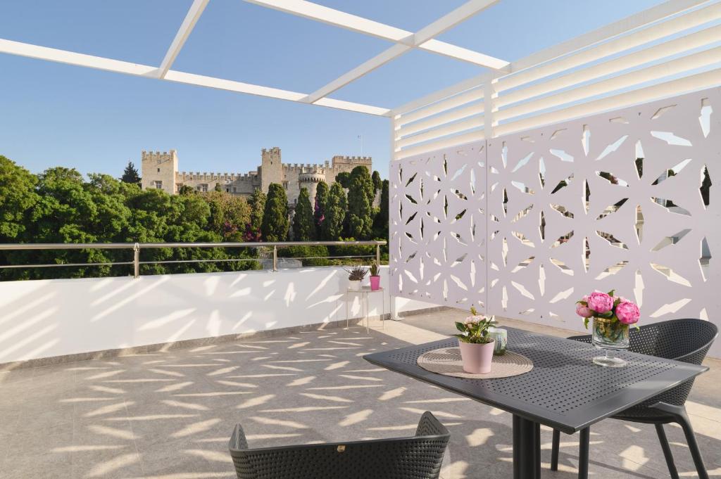 a patio with a table and chairs on a balcony at Castelo View Luxury apt in Rhodes Town