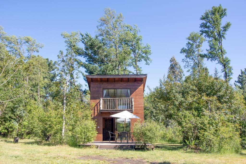 ein Holzhaus mitten auf einem Feld in der Unterkunft Cabaña campo Pucon in Pucón