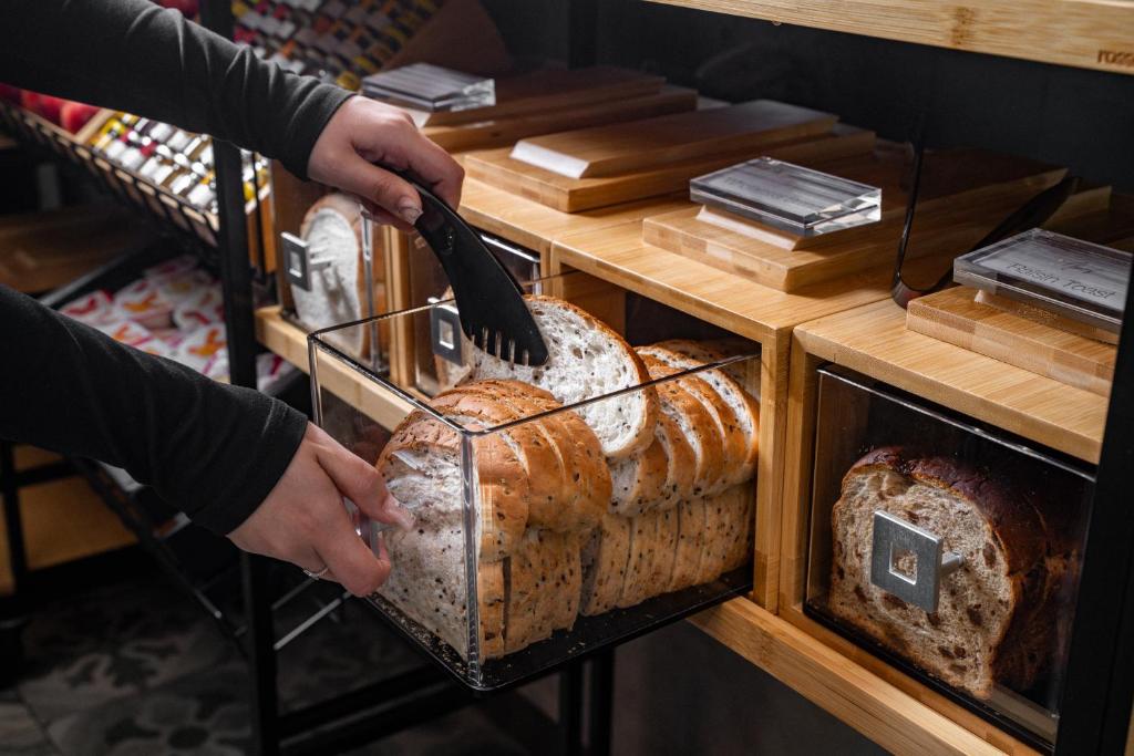 a person taking a loaf of bread from a bakery at Travelodge Hotel Hurstville Sydney in Sydney