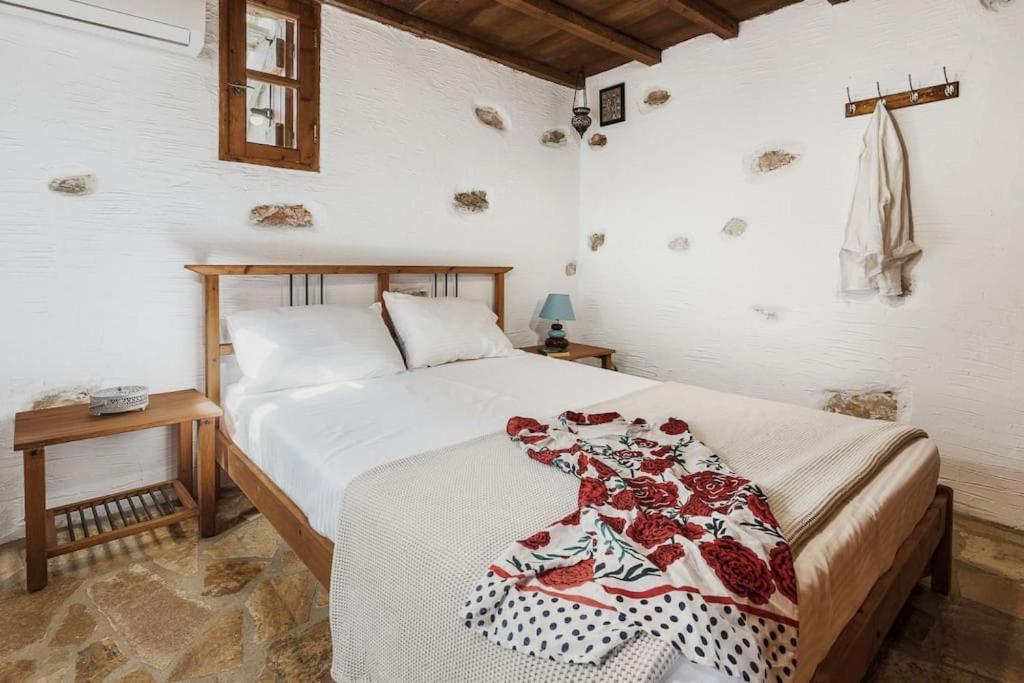 a bedroom with a bed and a table with a bedspread at Naxos Alyko Traditional Vacation House ''Mitatos'' in Naxos Chora