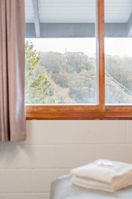 a window with a view of a mountain at YHA Thredbo in Thredbo