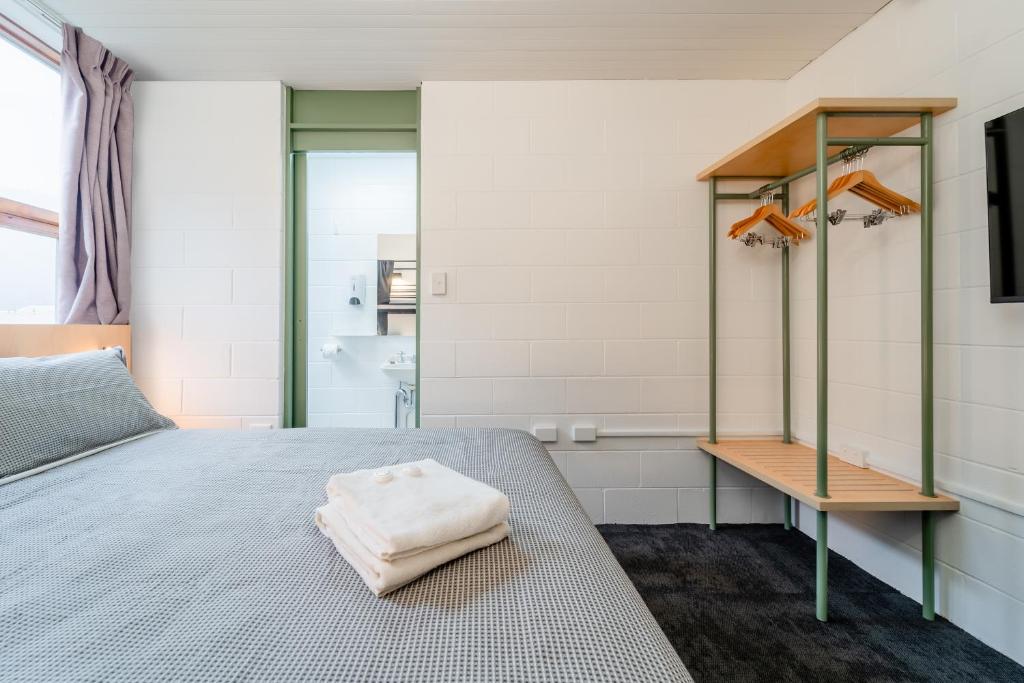 a bedroom with a bed with a towel on it at YHA Thredbo in Thredbo