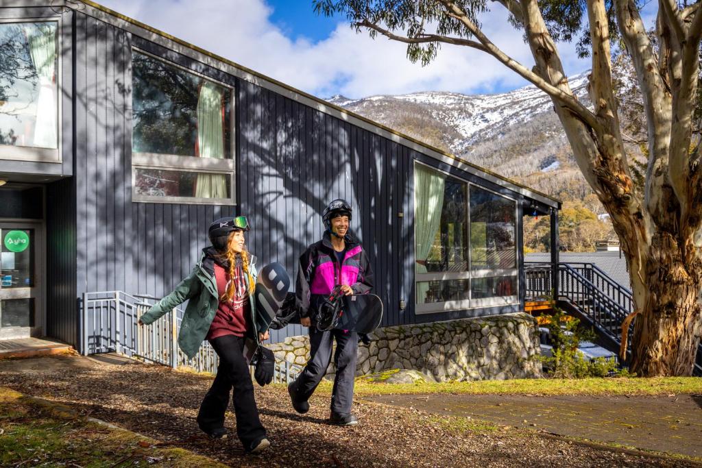 two people walking in front of a building at YHA Thredbo in Thredbo