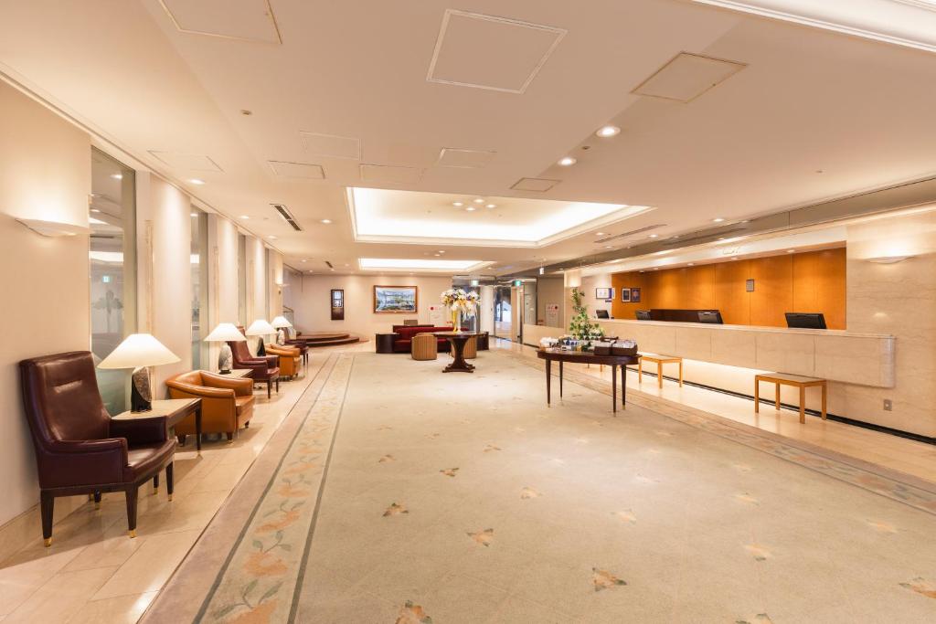 a lobby of a hospital with chairs and desks at Hotel Sunroute Niigata in Niigata