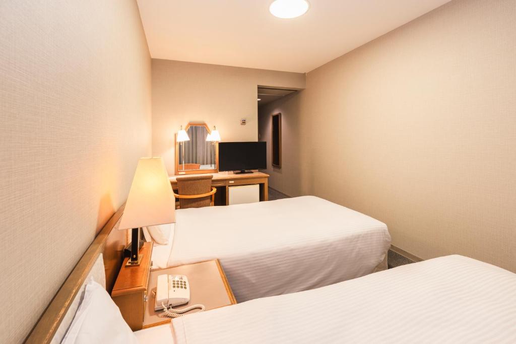 Postel nebo postele na pokoji v ubytování Hotel Sunroute Niigata