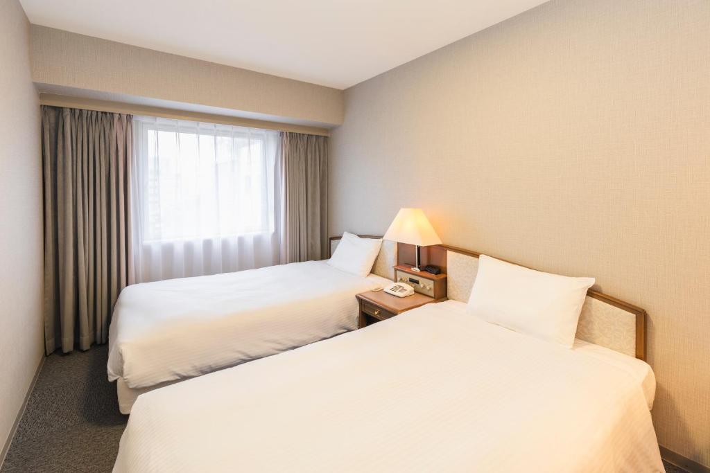 Postel nebo postele na pokoji v ubytování Hotel Sunroute Niigata