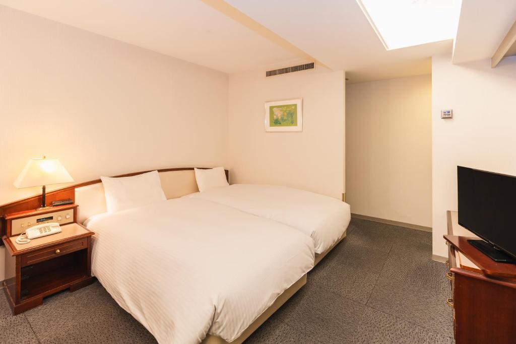 Postel nebo postele na pokoji v ubytování Hotel Sunroute Niigata