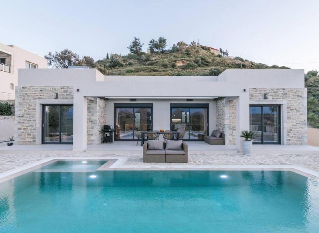 a house with a swimming pool in front of it at Villa Ida in Kamilari