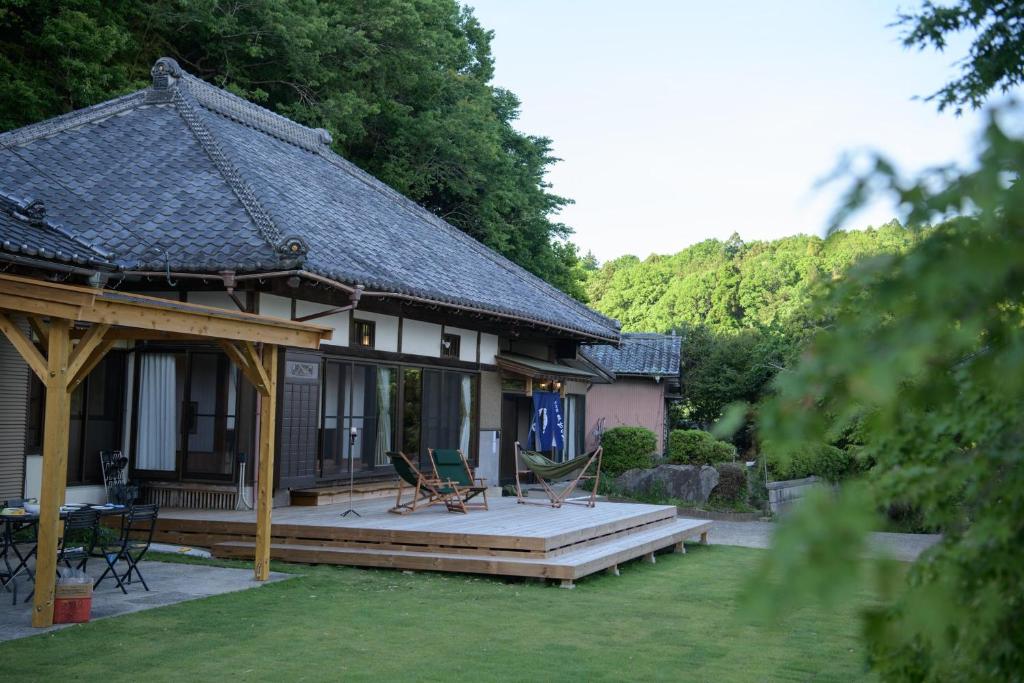a house with a porch and a deck with chairs at 多古の里 l 300平米超の古民家を一棟贅沢貸切 l BBQ ドッグラン in Tako