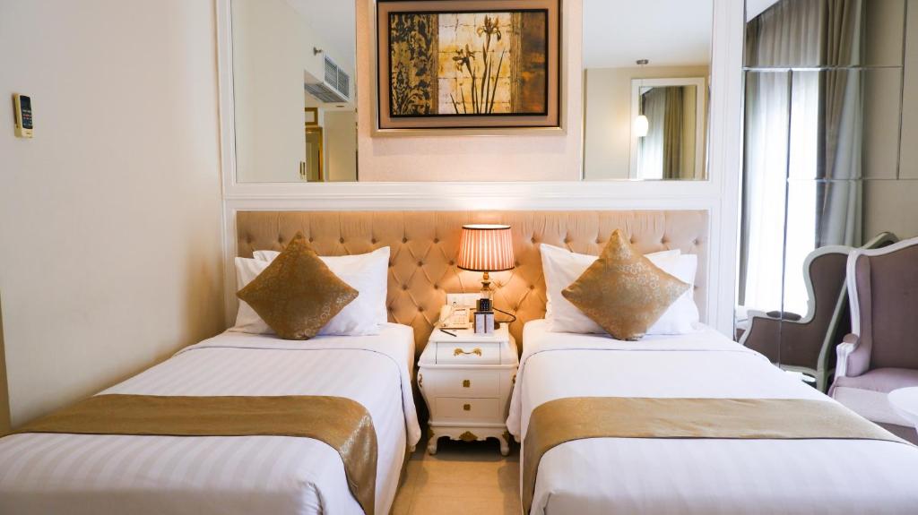 Postel nebo postele na pokoji v ubytování Grand Savero Hotel Bogor