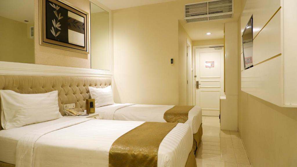 Postel nebo postele na pokoji v ubytování Grand Savero Hotel Bogor