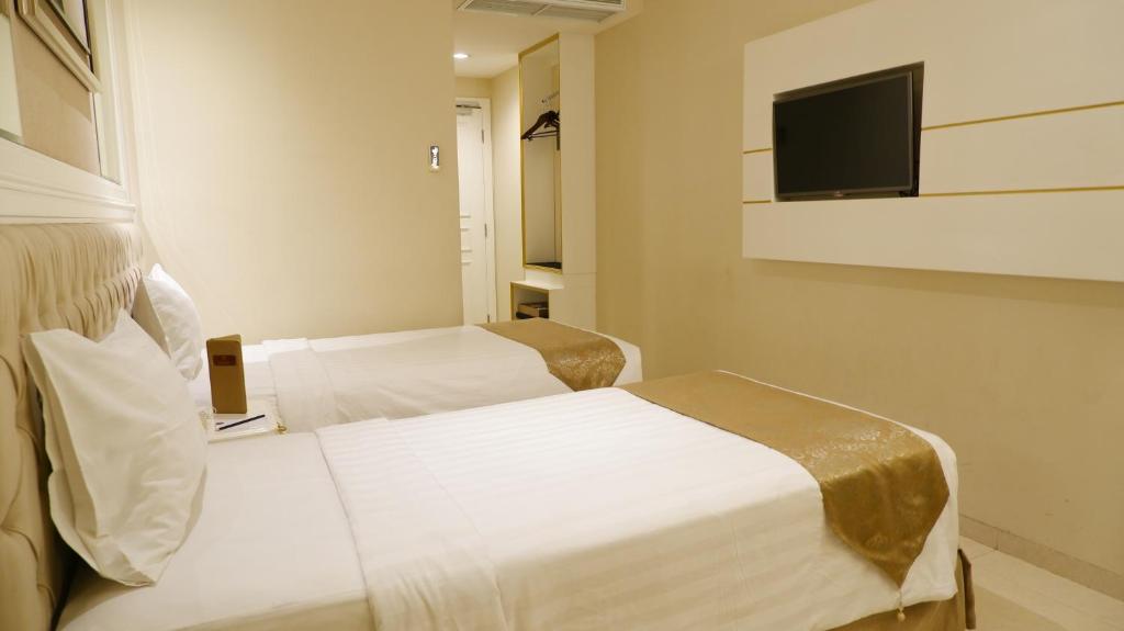 Postel nebo postele na pokoji v ubytování Grand Savero Hotel Bogor