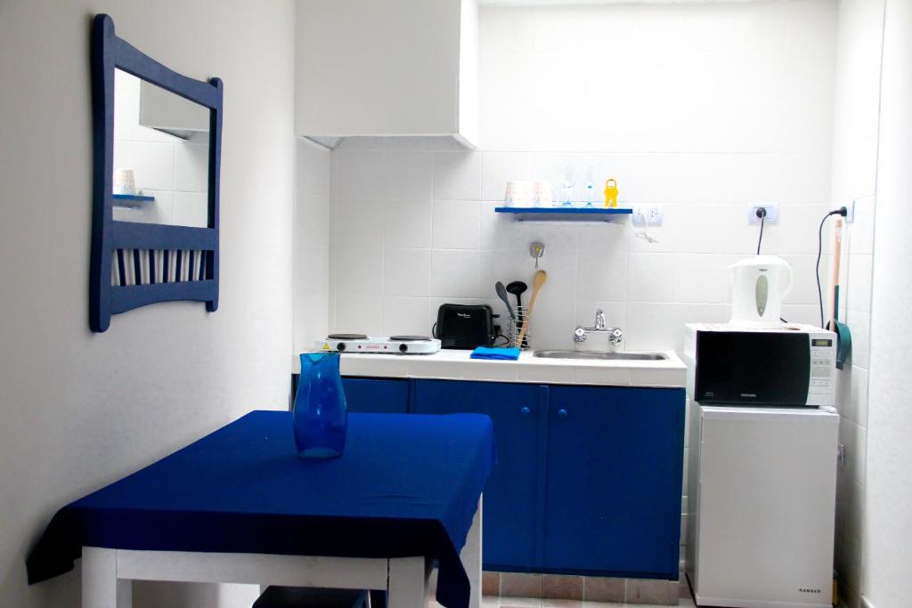 una pequeña cocina con mesa azul y fregadero en Apartamento Las Orquideas en Mendoza