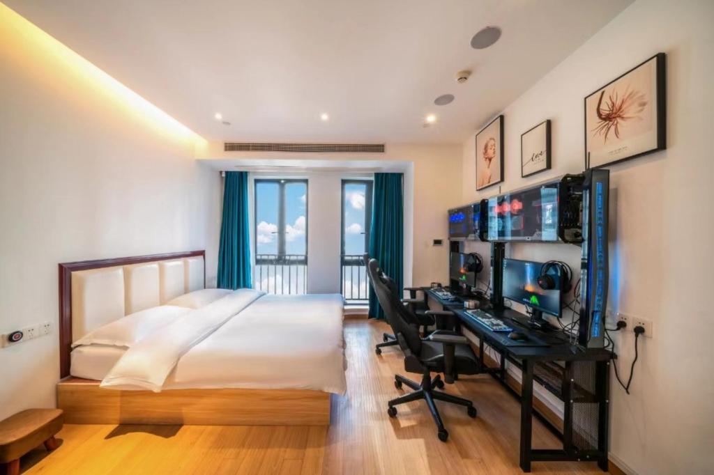 a bedroom with a bed and a desk with a computer at Muyu E-SPORT HOTEL慕鱼电竞酒店 in Chongqing