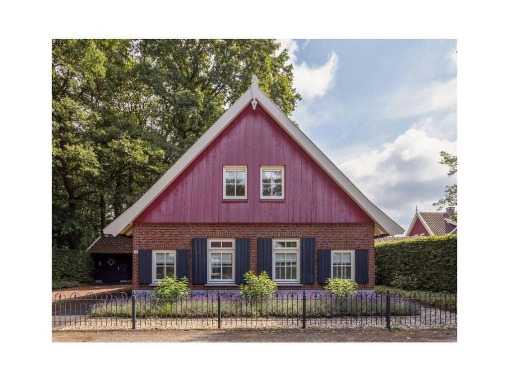 a red house with a gambrel roof at Winterswijk Modern retreat in Winterswijk-Meddo