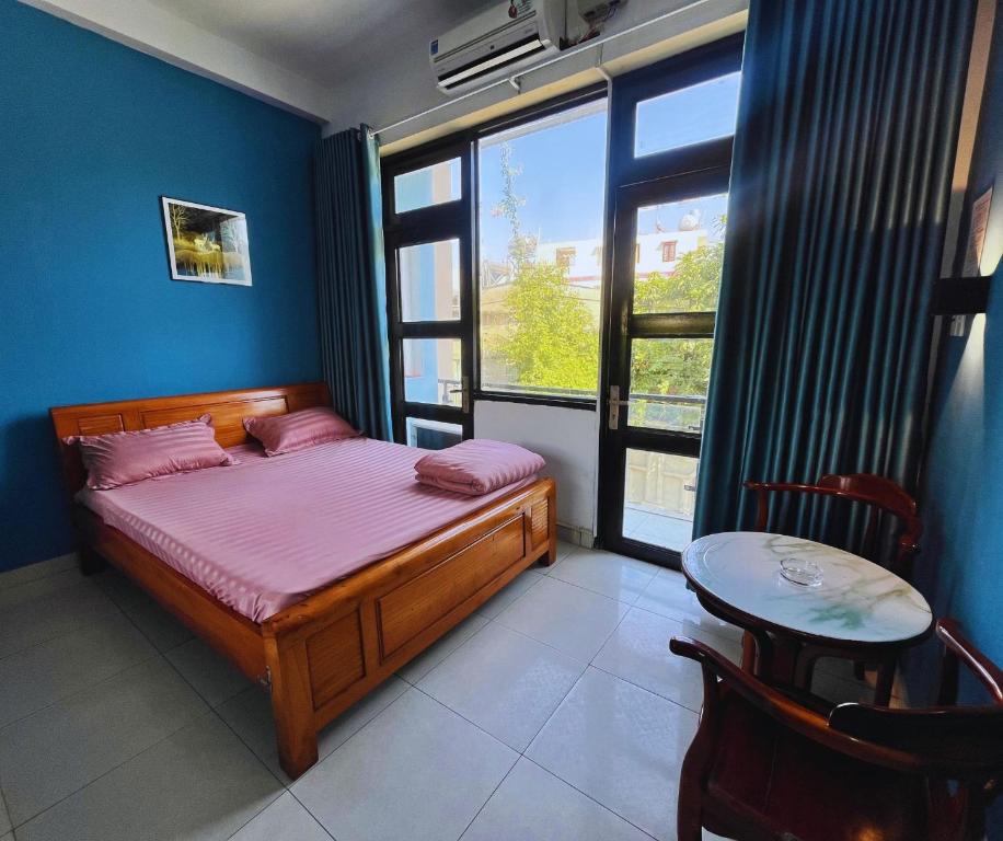 een slaapkamer met een bed, een tafel en een raam bij Nhà Nghỉ FAMI in Ho Chi Minh-stad