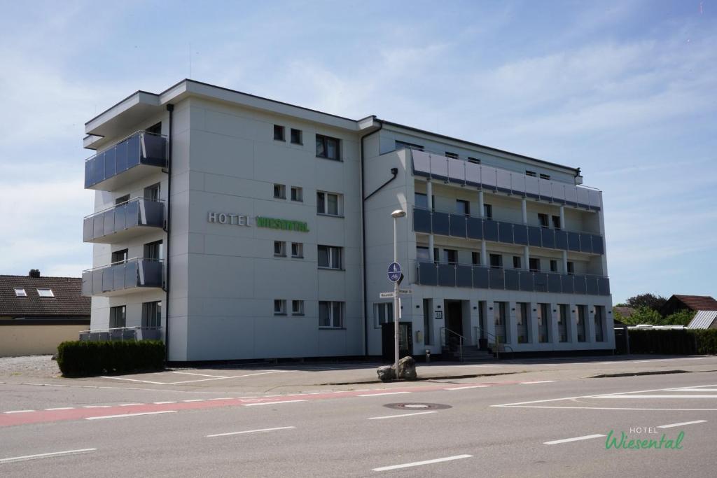 a large white building on the side of a street at Hotel Wiesental in Meckenbeuren