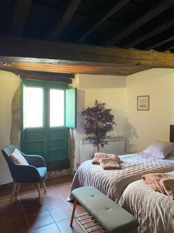 a bedroom with two beds and a green door at Casa Rural Cerro del Mariscal in Sequeros