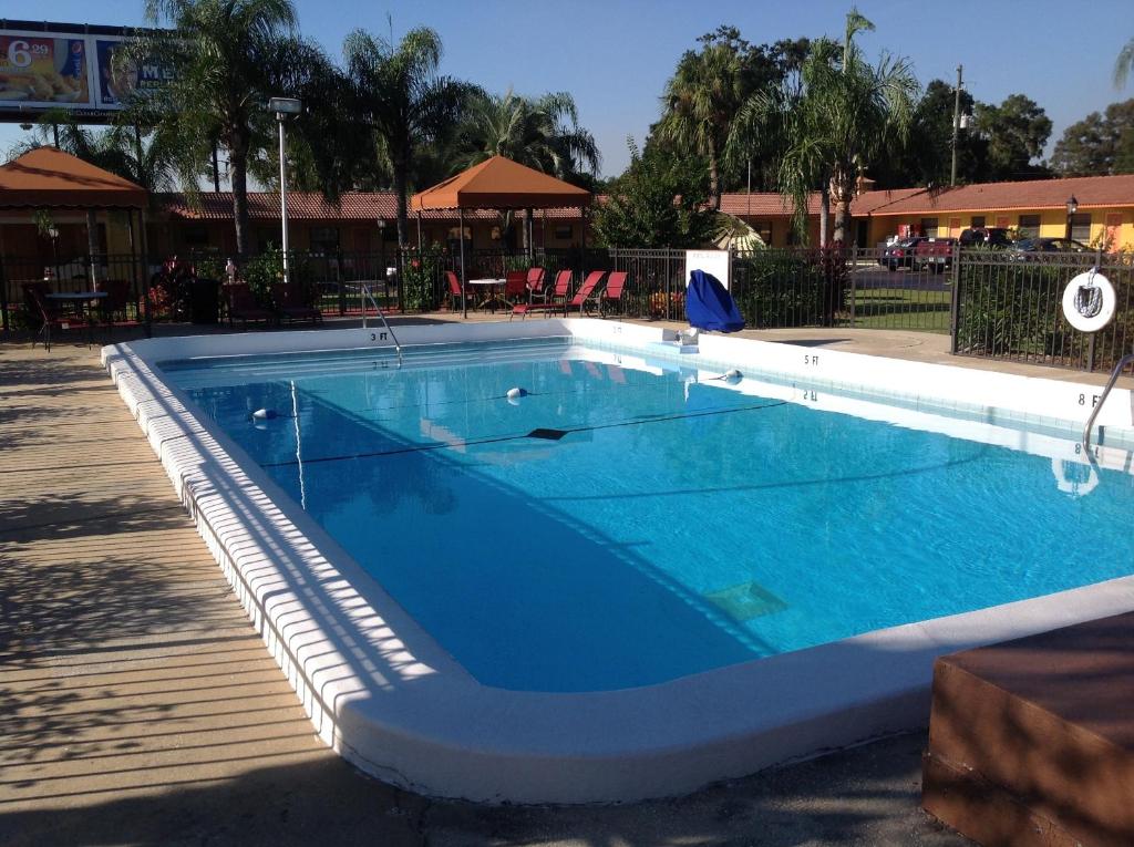 a swimming pool in a resort with blue water at Silver Princess Motel in Ocala