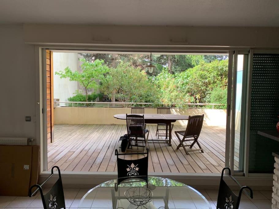 un patio avec une table et des chaises sur une terrasse dans l'établissement Super appartement arboré avec barbecue et parking, à Valence